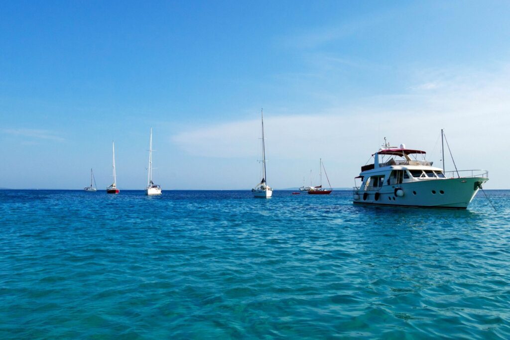 Recambios Marinos JJM, mantenimiento de embarcaciones en Sant Carles de La Ràpita. Barcos y veleros en el horizonte en el hermoso mar azul en verano.